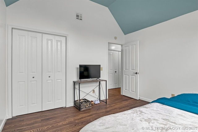 bedroom featuring wood finished floors, a closet, baseboards, and high vaulted ceiling