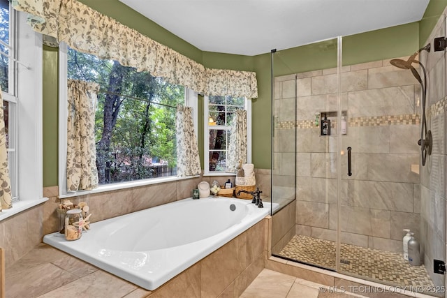 bathroom with a shower stall, a garden tub, and tile patterned floors