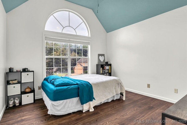 bedroom featuring lofted ceiling, wood finished floors, and baseboards