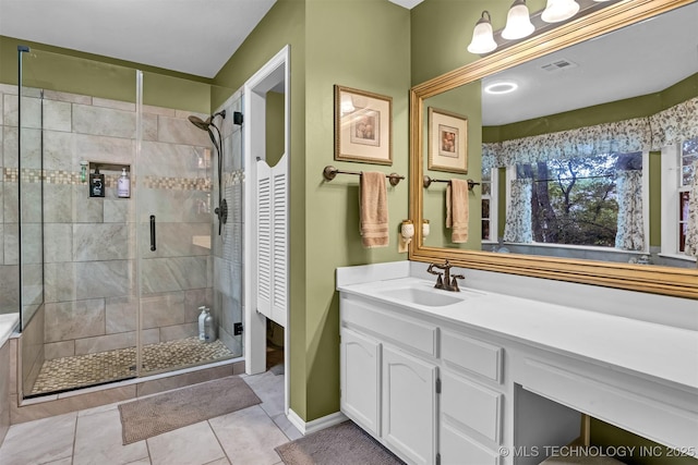 full bathroom with a shower stall, vanity, and tile patterned flooring