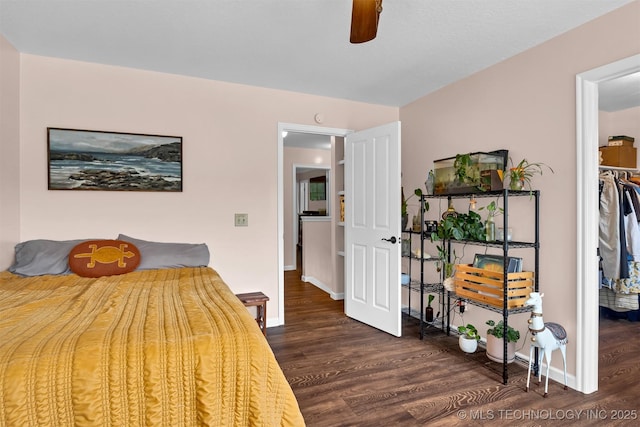 bedroom featuring dark wood-style flooring, baseboards, and a ceiling fan