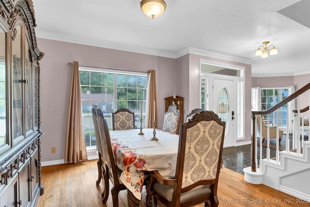 dining room with crown molding, baseboards, light wood-type flooring, a chandelier, and stairs