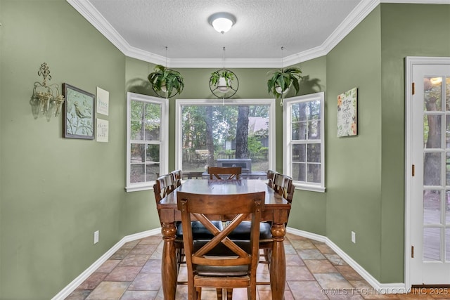 dining space with a textured ceiling, baseboards, stone tile floors, and crown molding