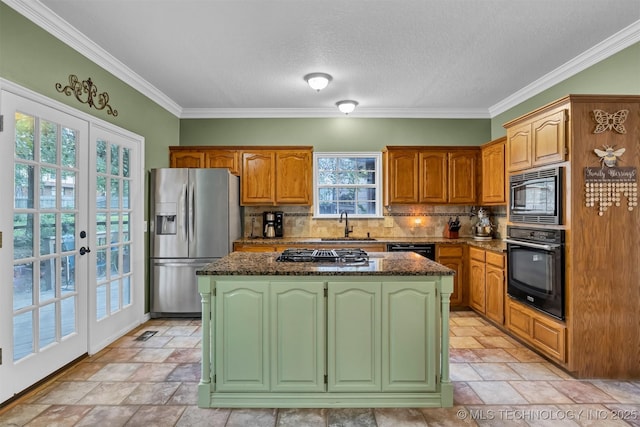 kitchen with black appliances, a center island, a sink, decorative backsplash, and stone tile floors