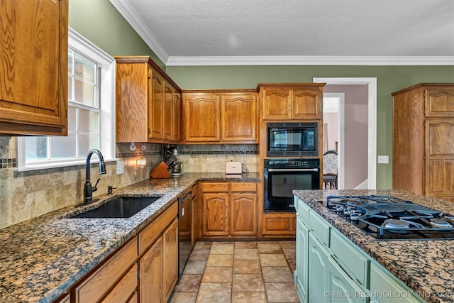kitchen featuring black appliances, a sink, decorative backsplash, dark stone countertops, and ornamental molding