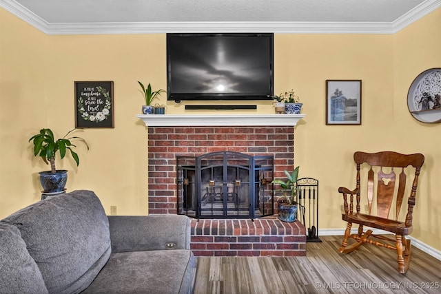 living room featuring wood finished floors, ornamental molding, a fireplace, and baseboards