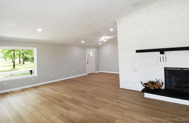 96358 S 4531, Vian, OK 74962 - unfurnished living room featuring healthy amount of natural light, a brick fireplace, baseboards, recessed lighting, and a textured ceiling
