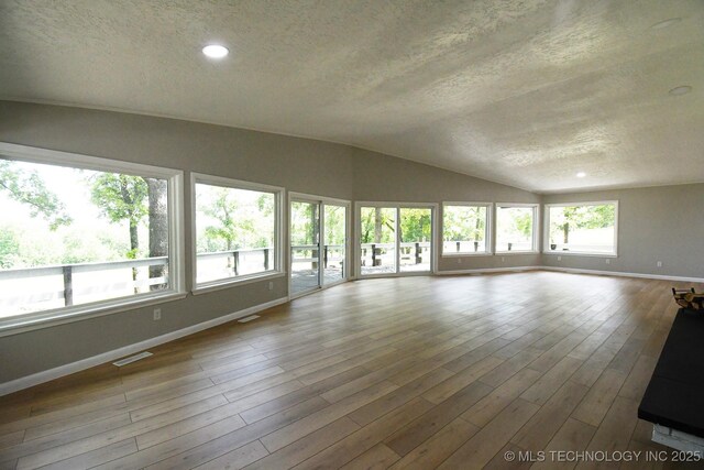 96358 S 4531, Vian, OK 74962 - unfurnished living room featuring baseboards, a textured ceiling, vaulted ceiling, wood finished floors, and recessed lighting
