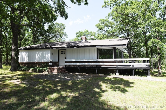 96358 S 4531, Vian, OK 74962 - view of front of home featuring a front yard, a chimney, a shingled roof, a deck, and board and batten siding