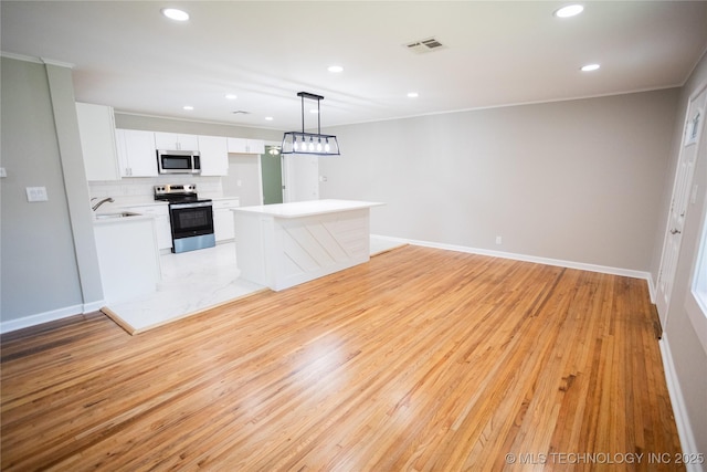 4024 E 25th St, Tulsa, OK 74114 - kitchen featuring stainless steel appliances, a sink, white cabinetry, light wood-type flooring, and recessed lighting