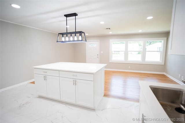 4024 E 25th St, Tulsa, OK 74114 - kitchen with light marble finish flooring, white cabinetry, ornamental molding, pendant lighting, and baseboards