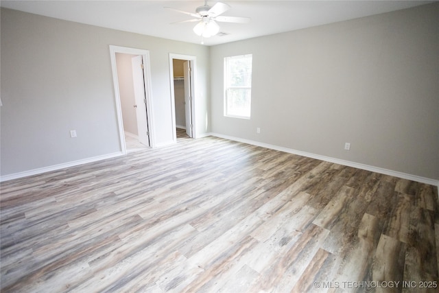 4024 E 25th St, Tulsa, OK 74114 - unfurnished bedroom featuring wood finished floors, baseboards, a spacious closet, and ceiling fan