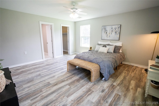 4024 E 25th St, Tulsa, OK 74114 - bedroom featuring wood finished floors, a walk in closet, baseboards, ceiling fan, and a closet