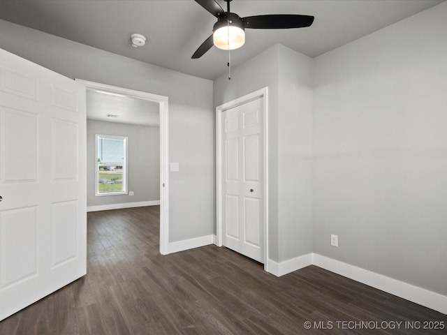 241 NE Debell Ave, Bartlesville, OK 74006 - unfurnished bedroom featuring dark wood-style floors, baseboards, and a ceiling fan