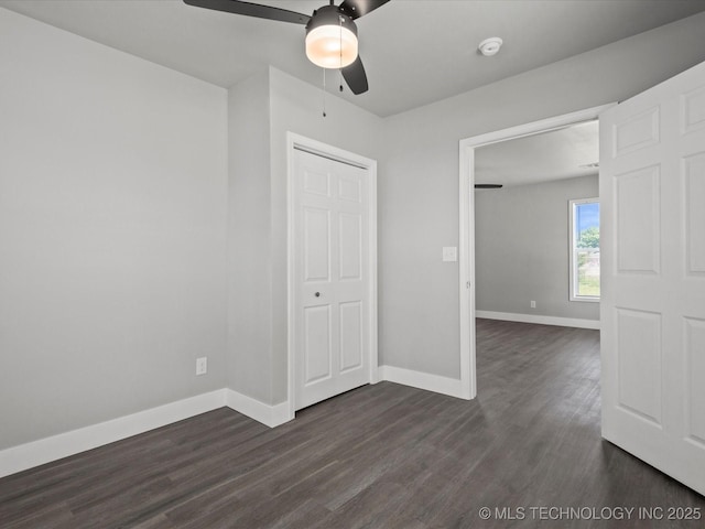 241 NE Debell Ave, Bartlesville, OK 74006 - unfurnished bedroom with dark wood-style floors, baseboards, and ceiling fan