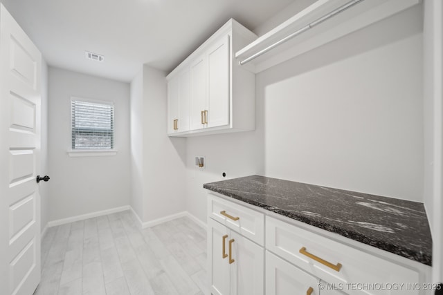 1305 N Dogwood Ave, Broken Arrow, OK 74012 - washroom featuring cabinet space, washer hookup, electric dryer hookup, baseboards, and light wood-type flooring