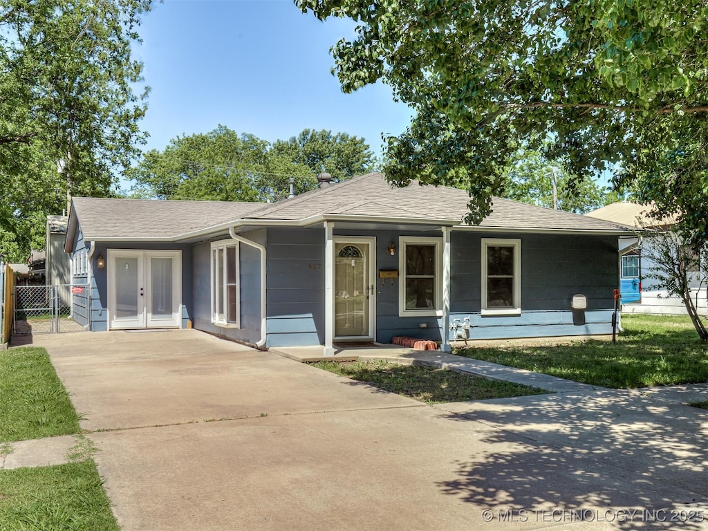 617 N Pawnee Ave, Dewey, OK 74029 - view of front facade with driveway, a shingled roof, and french doors