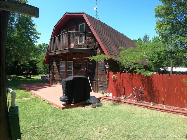 808 N Norfolk Rd, Yale, OK 74085 - rear view of property with a gambrel roof, a balcony, a shingled roof, and a patio area