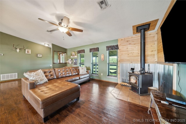 1202 S Oak Grove Rd, Cushing, OK 74023 - living area featuring a wood stove, ceiling fan, wood finished floors, vaulted ceiling, and baseboards