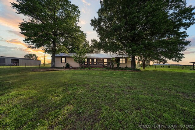 1202 S Oak Grove Rd, Cushing, OK 74023 - back of house at dusk featuring a lawn and metal roof