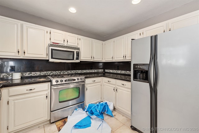 18268 S 79th E Ave, Bixby, OK 74008 - kitchen featuring stainless steel appliances, light tile patterned flooring, dark countertops, decorative backsplash, and recessed lighting