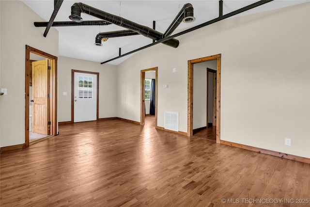 2382 Cheek, Lone Grove, OK 73443 - unfurnished living room featuring baseboards, wood finished floors, high vaulted ceiling, and beam ceiling