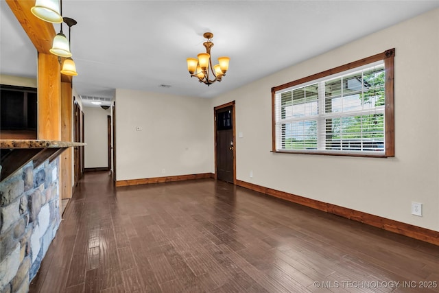2382 Cheek, Lone Grove, OK 73443 - unfurnished living room with baseboards, wood finished floors, and a chandelier