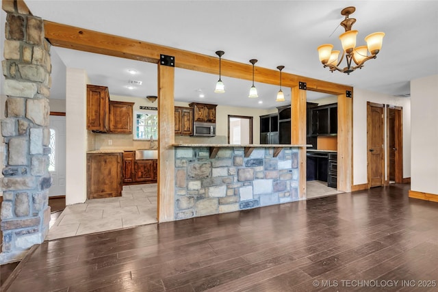 2382 Cheek, Lone Grove, OK 73443 - kitchen featuring stainless steel microwave, a chandelier, light wood-style floors, and decorative light fixtures