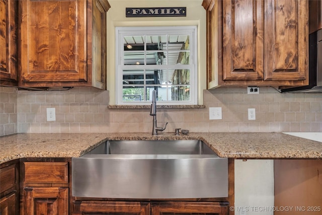 2382 Cheek, Lone Grove, OK 73443 - kitchen featuring a sink, decorative backsplash, light stone countertops, and brown cabinetry