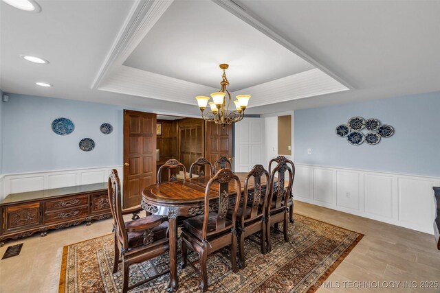 9417 S Gary Ave, Tulsa, OK 74137 - dining space with a chandelier, a tray ceiling, a wainscoted wall, recessed lighting, and a decorative wall