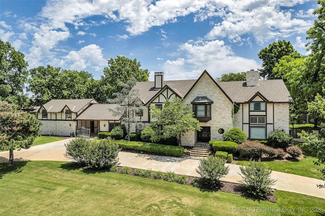 9417 S Gary Ave, Tulsa, OK 74137 - english style home featuring stone siding, a chimney, and a front yard