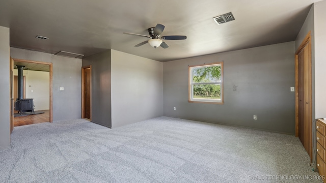 7941 N 433rd Rd, Adair, OK 74330 - unfurnished room with a wood stove, carpet, and a ceiling fan