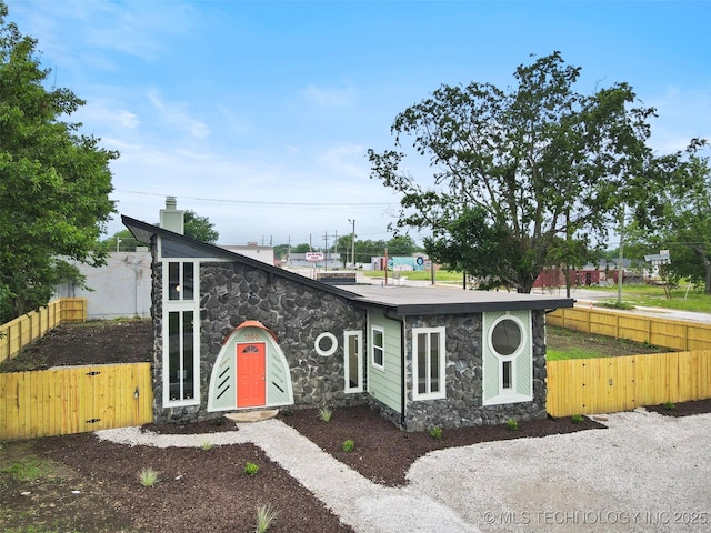 1550 E Apache St N, Tulsa, OK 74106 - mid-century home featuring stone siding, a gate, and a chimney
