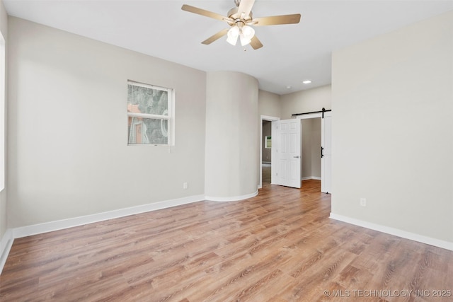 1550 E Apache St N, Tulsa, OK 74106 - unfurnished room featuring ceiling fan, light wood finished floors, baseboards, recessed lighting, and a barn door