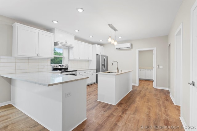 1550 E Apache St N, Tulsa, OK 74106 - kitchen featuring appliances with stainless steel finishes, an AC wall unit, a sink, decorative backsplash, and light wood finished floors