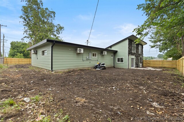 1550 E Apache St N, Tulsa, OK 74106 - rear view of house featuring a fenced backyard, a wall unit AC, and cooling unit