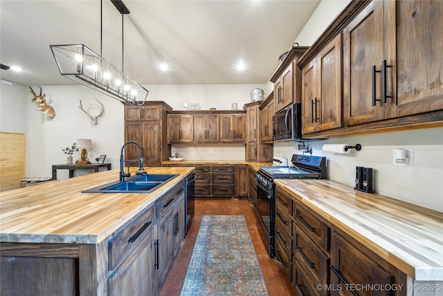 17784 S 210th Rd, Okmulgee, OK 74447 - kitchen featuring wooden counters, black appliances, a sink, an island with sink, and decorative light fixtures