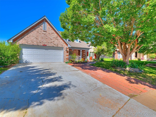 8704 N 140th E Ct, Owasso, OK 74055 - view of front of home with driveway, a garage, brick siding, and a porch