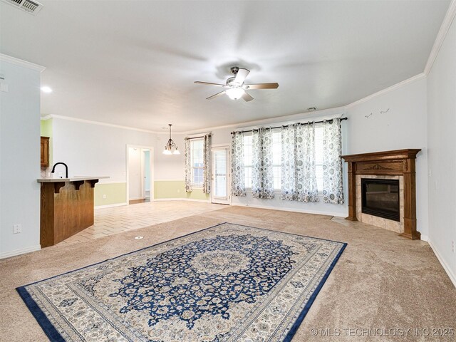 8704 N 140th E Ct, Owasso, OK 74055 - unfurnished living room with ceiling fan, crown molding, light carpet, a fireplace, and a chandelier