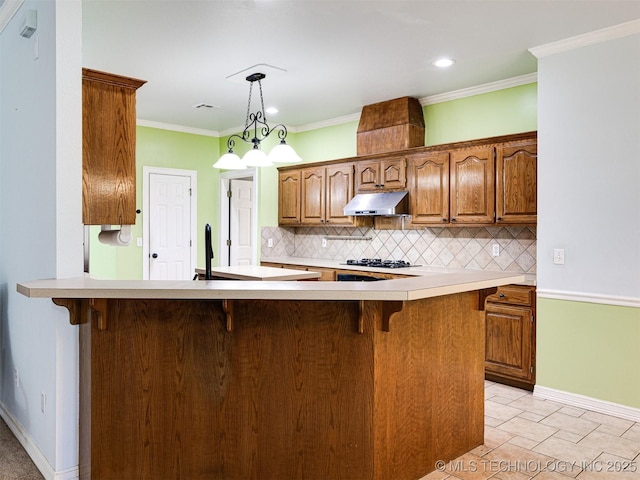8704 N 140th E Ct, Owasso, OK 74055 - kitchen featuring backsplash, under cabinet range hood, a kitchen breakfast bar, gas stovetop, and recessed lighting