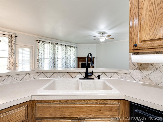 8704 N 140th E Ct, Owasso, OK 74055 - kitchen featuring a sink, light countertops, dishwasher, ornamental molding, and ceiling fan