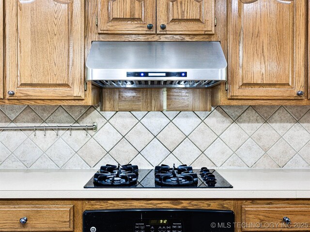 8704 N 140th E Ct, Owasso, OK 74055 - kitchen with wall chimney exhaust hood, black gas stovetop, light countertops, and brown cabinetry