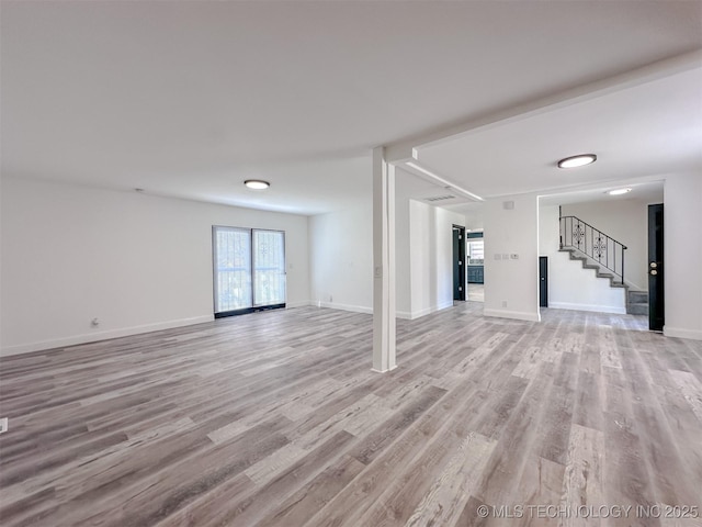 2212 W Independence Pl, Tulsa, OK 74127 - unfurnished living room with light wood finished floors, stairs, and baseboards