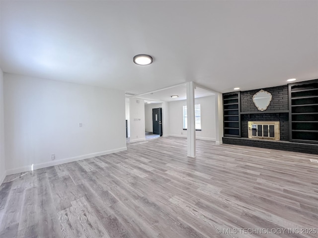 2212 W Independence Pl, Tulsa, OK 74127 - unfurnished living room with baseboards, built in shelves, light wood-style floors, and a fireplace