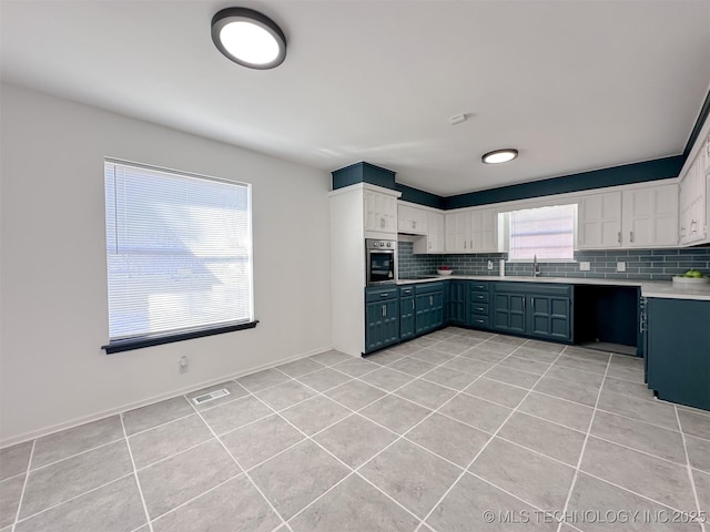 2212 W Independence Pl, Tulsa, OK 74127 - kitchen with light tile patterned floors, tasteful backsplash, stainless steel oven, and light countertops