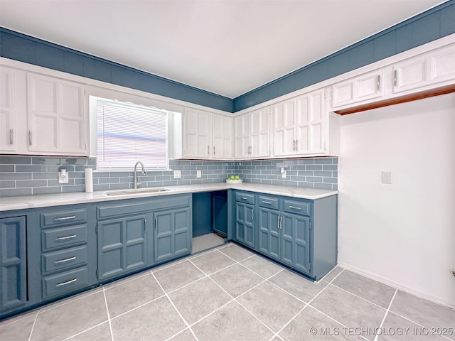 2212 W Independence Pl, Tulsa, OK 74127 - kitchen with a sink, blue cabinetry, light countertops, decorative backsplash, and light tile patterned floors