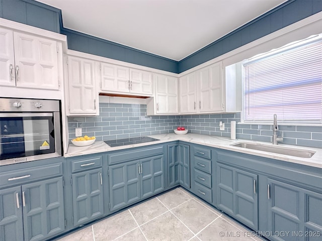 2212 W Independence Pl, Tulsa, OK 74127 - kitchen with oven, a sink, black electric cooktop, tasteful backsplash, and light tile patterned floors