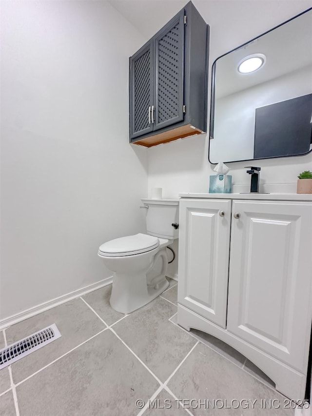 2212 W Independence Pl, Tulsa, OK 74127 - half bathroom featuring tile patterned floors, toilet, vanity, and baseboards
