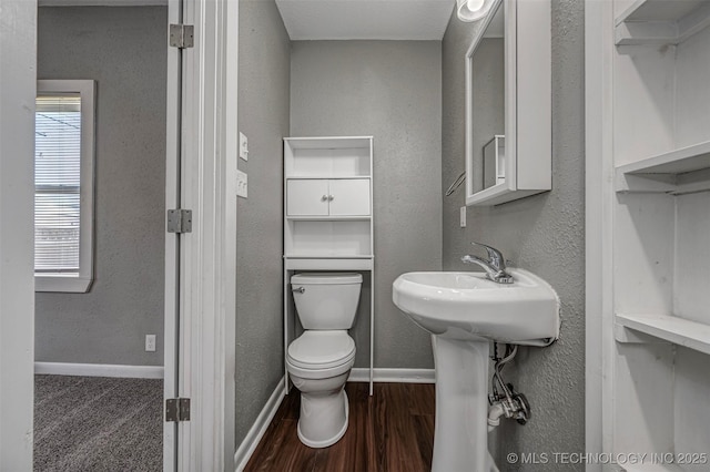 423 E Cherry St, Cushing, OK 74023 - bathroom with toilet, wood finished floors, baseboards, and a sink
