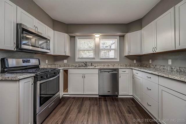 423 E Cherry St, Cushing, OK 74023 - kitchen featuring appliances with stainless steel finishes, a sink, white cabinetry, and light stone counters